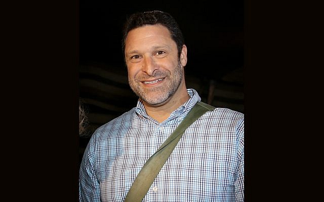 Montage of file photo of Ari Fuld, father of four, and resident of Efrat. Fuld was a member of the emergency squad in Gush Etzion, pictured here at a celebratory event on October 31, 2017, carrying his rifle (Gershon Elinson/FLASH90)