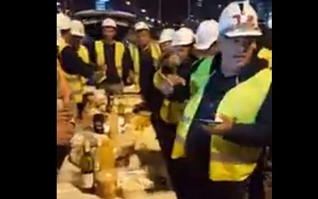 Construction workers make kiddush on site, January 25, 2019. (Screen capture, YouTube)