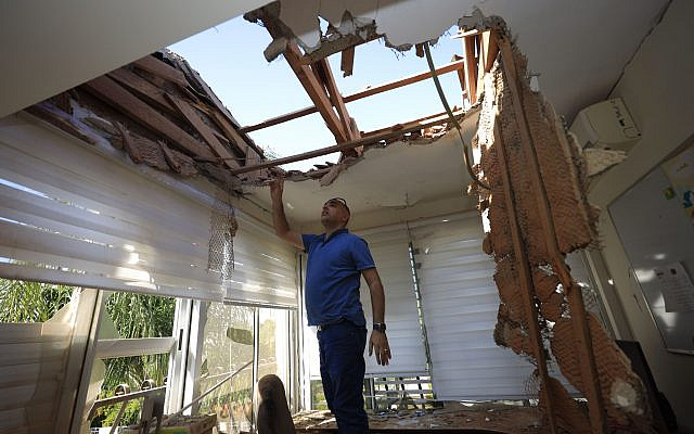 A man looks at the damage to a house in Sderot, Israel, after it was hit by a rocket fired from Gaza Strip, November 12 2019. (Tsafrir Abayov/AP)