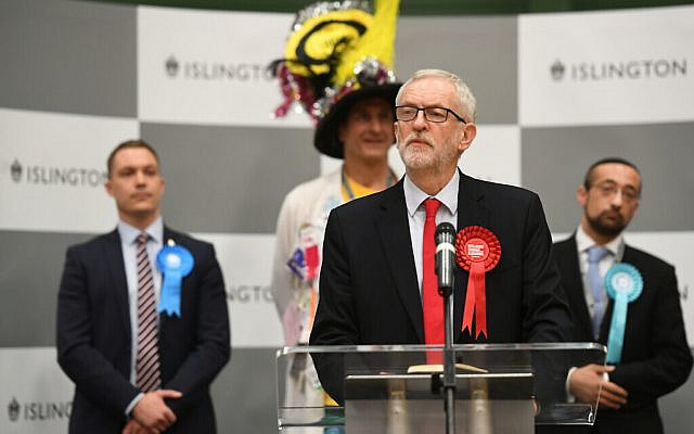 Labour leader Jeremy Corbyn speaks after winning his seat in the election - but witnessing his party suffering heavy losses. On the right is Jewish Brexit Party candidate, Yosef David. (Photo credit: Joe Giddens/PA Wire)