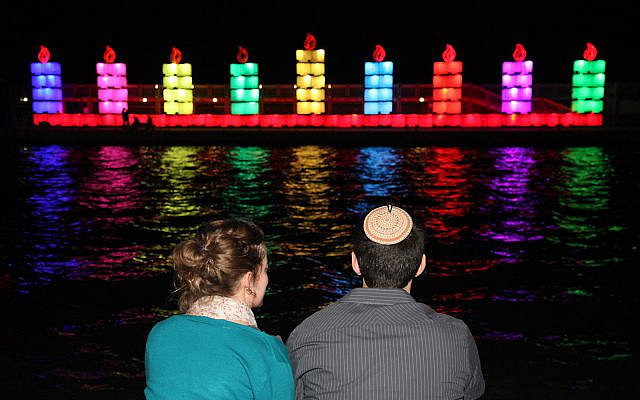 An Israeli couple watch the world's largest Hanukkah menorah in Tel Aviv Port on November 25, 2013. (Gideon Markowicz/Flash90)
