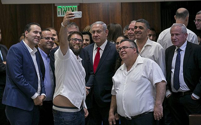 Likud MK Oren Hazan takes a selfie with Prime Minister Benjamin Netanyahu, center, and MK David Bitan, right of Netanyahu, after the passage of the nation-state law at the Knesset on July 19, 2018. (AP Photo/Olivier Fitoussi)