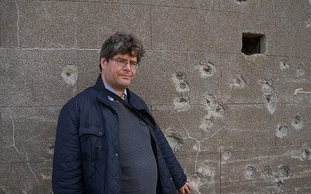 Marcus Roberts standing next to a wall on Alderney believed to be an execution site.