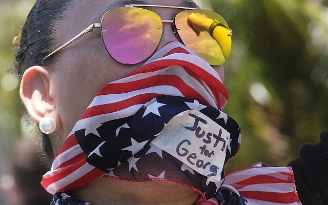A protester wears a US flag bandana during a protest over the death of George Floyd in Los Angeles, Saturday, May 30, 2020. (AP Photo/Ringo H.W. Chiu)