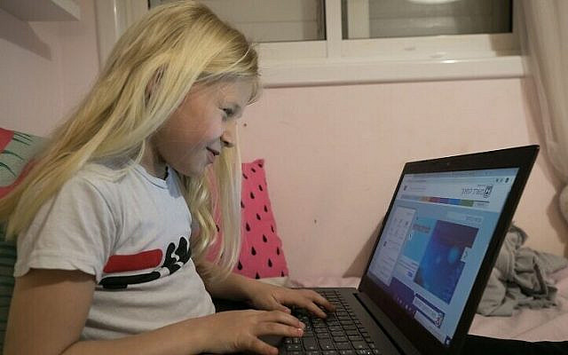 An Israeli schoolchild engaging in remote learning at her home in Moshav Haniel, in central Israel, March 18, 2020. (Chen Leopold/Flash90)