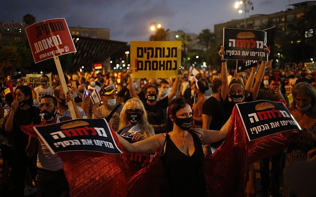 Protesters hold signs during a demonstration against Israel's government in Rabin square in Tel Aviv, Israel, July 11, 2020. (AP Photo/Ariel Schalit)