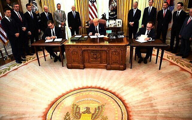 US President Donald Trump signs a document as Kosovar Prime Minister Avdullah Hoti (R) and Serbian President Aleksandar Vucic (L)  sign an agreement on opening economic relations, in the Oval Office of the White House in Washington, DC, on September 4, 2020. (Photo by Brendan Smialowski / AFP)