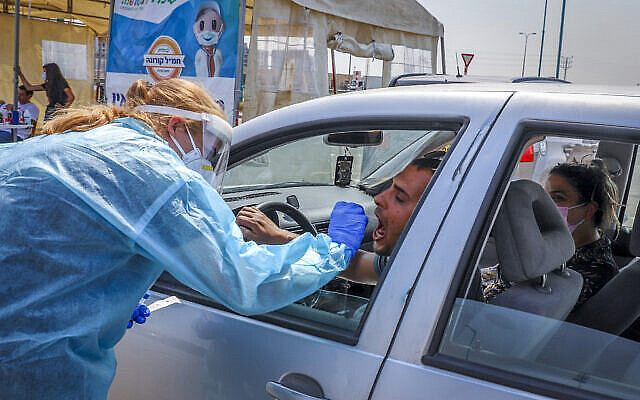 Clalit healthcare workers test Israelis for the coronavirus at a drive-through mobile testing station, in Lod, on September17, 2020. (Yossi Aloni/FLASH90)