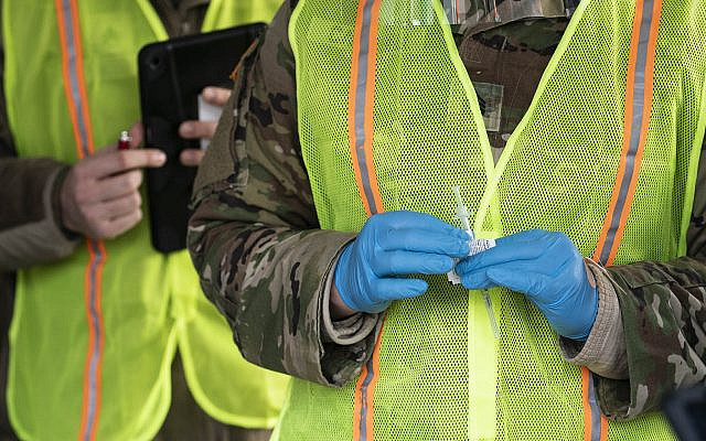Members of the National Guard prepare to inject the coronavirus vaccine at a mass vaccination site in the parking lot of Six Flags in Bowie, Md., Feb. 6, 2021.(Sarah Silbiger/Getty Images)
