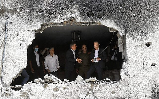 German Foreign Minister Heiko Maas and his Israeli counterpart Gabi Ashkenazi (C) visit a building that was hit by Hamas rocket fire from Gaza, on May 20, 2021, in Petah Tikva. (Gil COHEN-MAGEN / AFP)