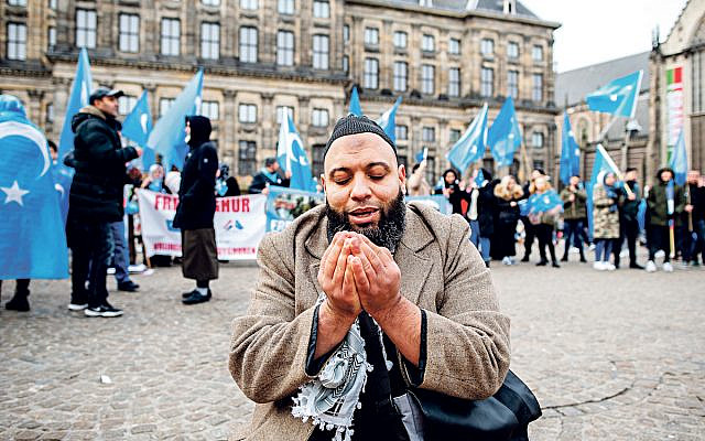 A muslim is praying before the demonstration in solidarity with the Uyghurs, started in Amsterdam, on December 29th, 2019. (Photo by Romy Arroyo Fernandez/NurPhoto)