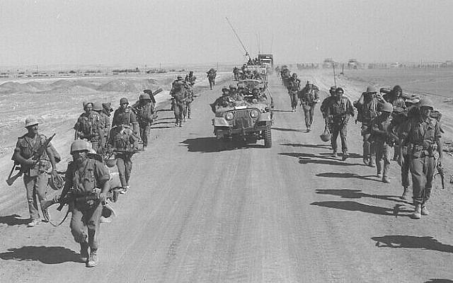 Israeli paratroopers march along the Suez-Cairo road after crossing the Suez Canal, October 1973. (Ron Ilan / GPO)