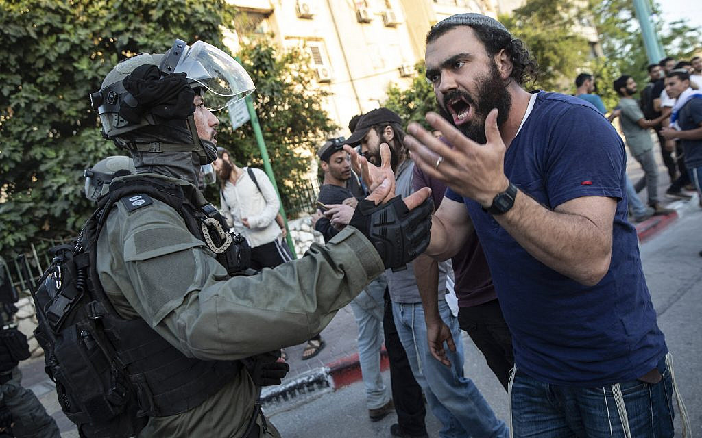 Israeli riot police face off with a Jewish man as clashes erupted between Arabs, police and Jews, in the mixed town of Lod, central Israel, Wednesday, May 12, 2021. (AP Photo/Heidi Levine)