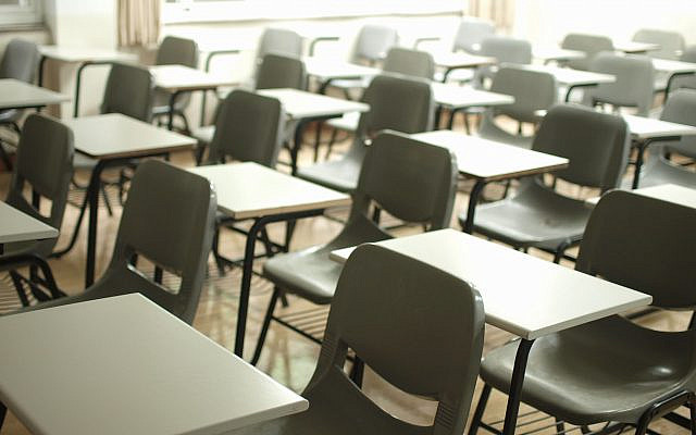 A classroom with empty chairs and desks. (Unsplash)