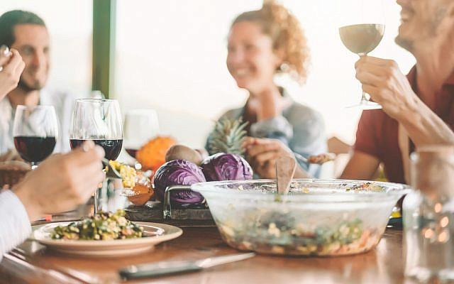 Happy friends eating vegetarian food and drinking red wine - Vegan family dining fresh vegetables in farmhouse - Healthy people lifestyle and cooking culture concept