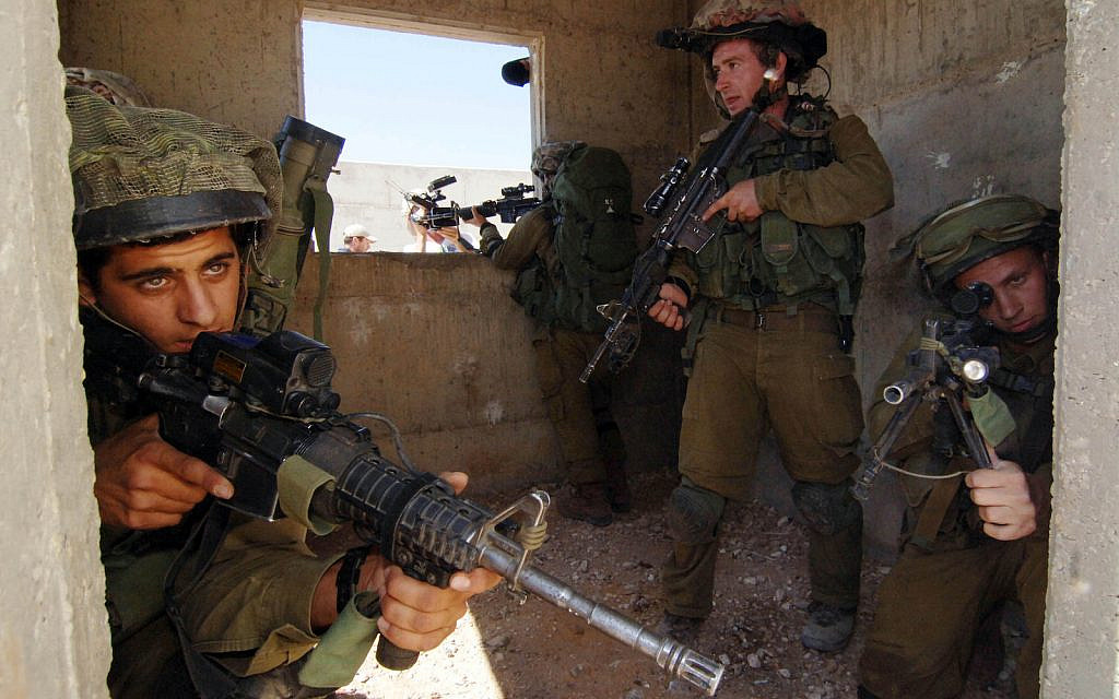 Israeli soldiers from the Paratroopers Brigade take part in a training exercise where they practice how to fight door to door combat in inhabited areas in Tze'elim, southern Israel, July 10, 2014. (Flash90)