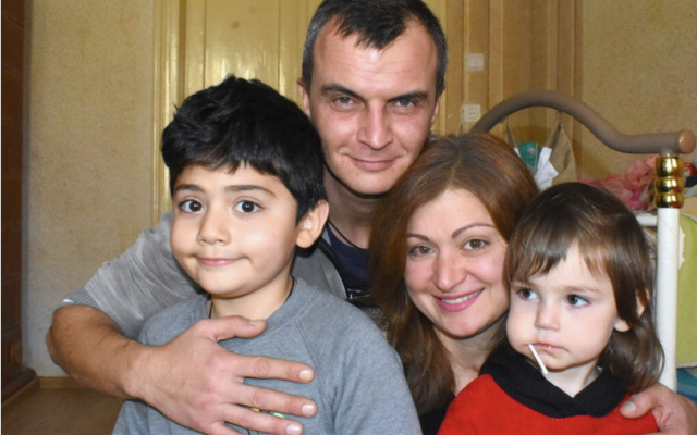 Yuriy Galyulko and Karina Pietoian with 8-year-old son Eldar, who has Duchenne muscular dystrophy, and their healthy daughter, Margarita, 3, at home in Lviv, Ukraine. (Photo by Larry Luxner)