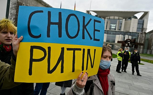 Demonstrators hold a placard reading 'Choke Putin' in front of the Chancellery in Berlin as they protest, on February 24, 2022, against Russia's invasion of Ukraine. (John Macdougall/AFP)