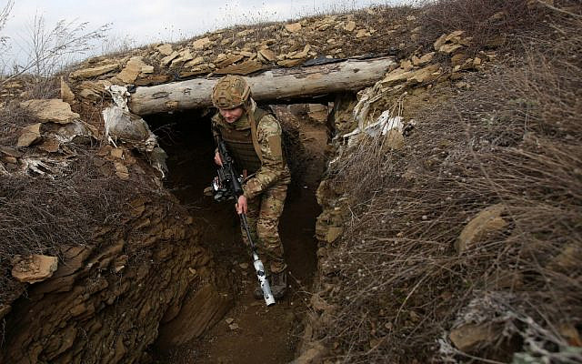 A Ukrainian serviceman walks along a trench at a position on the front line with Russia-backed separatists near the settlement of Troitske in the Lugansk region on February 22, 2022 (Anatolii STEPANOV / AFP)