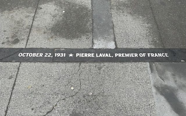 A sidewalk plaque along Manhattan's "Canyon of Heroes" remembers a ticker-tape parade in 1931 honoring Pierre Laval, who would go on to serve as the head of France's Nazi-aligned Vichy government. (Jacob Fishman)