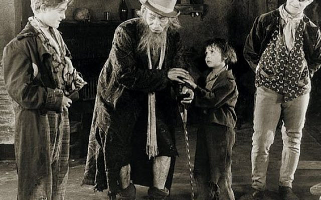 Oliver Twist (Jackie Coogan) held captive, by Fagin (Lon Chaney) and his criminal gang in Oliver Twist (1922 film)