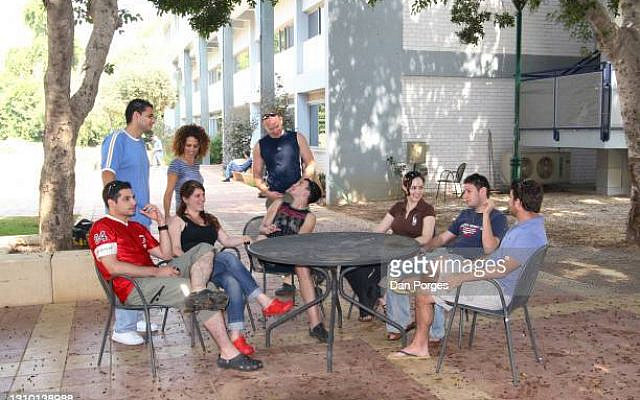 View of a group of students as they talk together at an outdoor table on the campus of the Afeka College of Engineering, Tel Aviv, Israel, June 21, 2007. (Photo by Dan Porges/Getty Images)