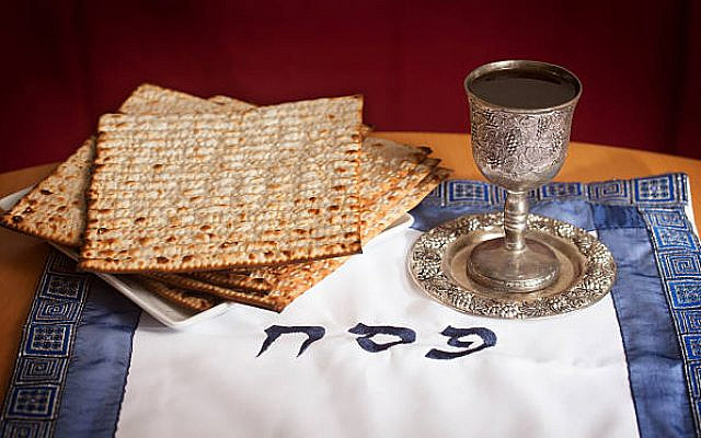 Matzo and a wine in a Kiddush cup with the words PESACH (Passover in Hebrew).