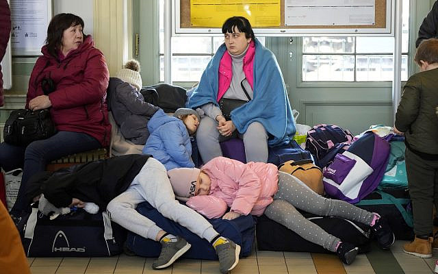 Illustrative: Children from Ukraine sleep on luggage at a railway station in Przemysl, southeastern Poland, on Wednesday, March 23, 2022. (AP Photo/Sergei Grits, File)