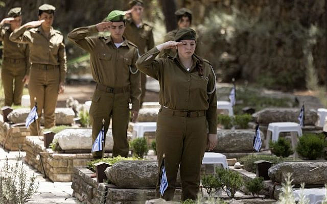 Israeli soldiers pay their respect at the Mount Herzl military cemetery in Jerusalem on May 2, 2022, a day ahead of the Yom HaZikaron (Israel's Memorial Day). - Israel will mark the Remembrance Day after sunset to commemorate over 24,068 fallen soldiers and fighters since 1860, just before the celebrations of the 74th anniversary of its creation according to the Jewish calendar. (Photo by MENAHEM KAHANA / AFP) (Photo by MENAHEM KAHANA/AFP via Getty Images)