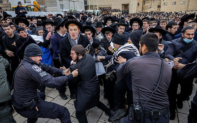 Haredi ultra-Orthodox Jews scuffle with police as they protest members of the Women of the Wall movement holding Rosh Hodesh prayers at the Western Wall in Jerusalem, March 4, 2022. (Yonatan Sindel/Flash90)