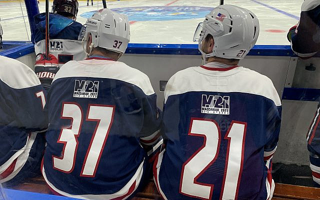 Evan Kearns (left) sitting next to his brother Kenneth Kearns (right) during the Unites States' hockey game against Team Europe. Photo by Dylan Manfre