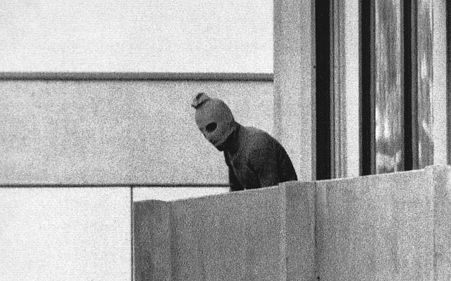 A member of the terrorist group that seized members of the Israeli Olympic Team at their quarters at the Olympic Village appearing with a hood over his face stands on the balcony of the building where they held members of the Israeli team hostage in Munich, September 5, 1972.  (AP/Kurt Strumpf)