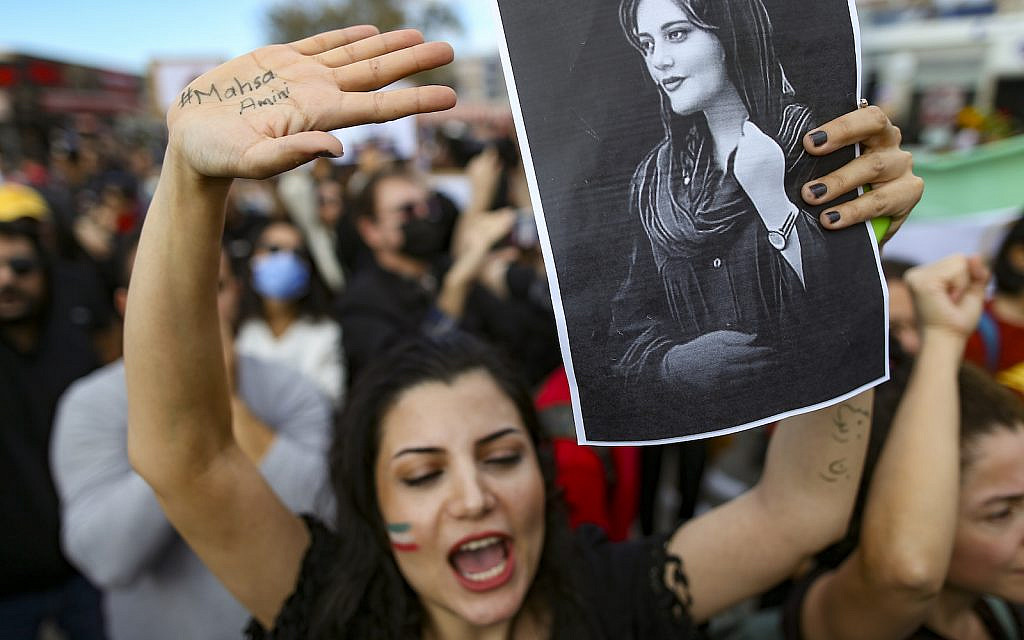 A woman in Istanbul holds up a drawing of Iranian Mahsa Amini during a protest against her death, Sunday, Oct. 2, 2022 (AP Photo/Emrah Gurel)