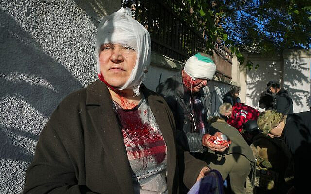 People receive medical treatment at the scene of Russian shelling, in Kyiv, Ukraine, Monday, Oct. 10, 2022. Two explosions rocked Kyiv early Monday following months of relative calm in the Ukrainian capital. (AP Photo/Efrem Lukatsky)