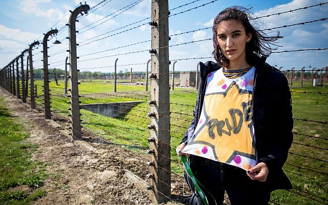 Danielle Yablonka stands at the Auschwitz-Birken concentration camp in Poland wearing a shirt she spraypainted with a yellow star and says “pride”. | Photo Courtesy of Danielle Yablonka