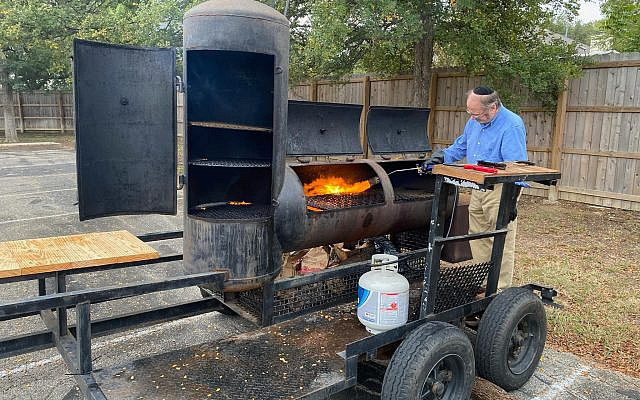 Rabbi Steven Bayar kashering a barbecue before the big event. Credit: Congregation Agudas Achim.