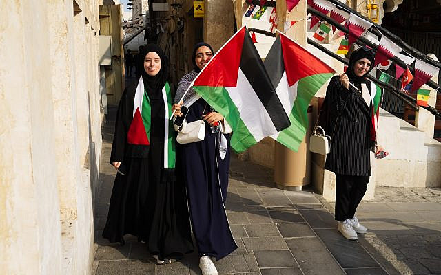 Palestinian women wave the Palestinian flag ahead of the FIFA World Cup in Doha, Qatar, November 19, 2022. (AP Photo/Jon Gambrell)