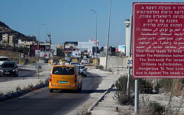 Illustrative. A red sign on the side of a road warns Israeli citizens against entering the West Bank city of Nablus on July 29, 2015. (Garrett Mills/Flash90/File)