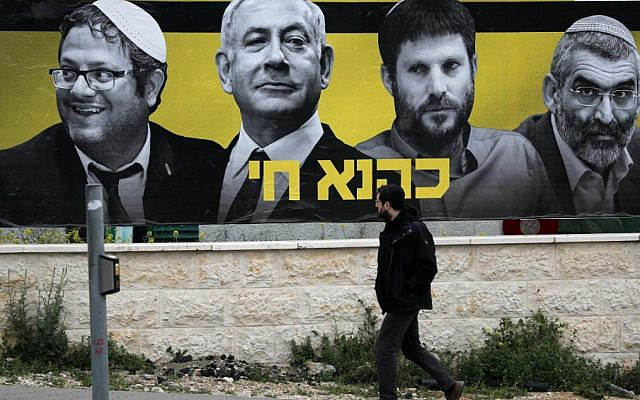 An Israeli man walks past an electoral billboard bearing portraits of Netanyahu flanked by extreme-right politicians, including Itamar Ben-Gvir and Bezalel Smotrich, in Jerusalem in 2019 (AFP)