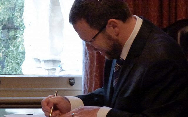 The author signing the judicial affirmation of independence at Government House, Perth on 17 June 2011