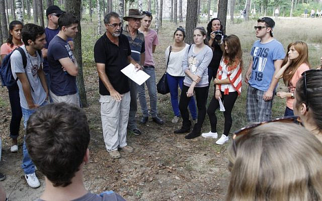 Archaeologist Yoram Haimi talking to young people from the Dror School in Israel about his findings at the site of the former German Nazi death camp of Sobibor, in eastern Poland, on Tuesday, Aug. 21, 2012 (photo credit: AP/Czarek Sokolowski)