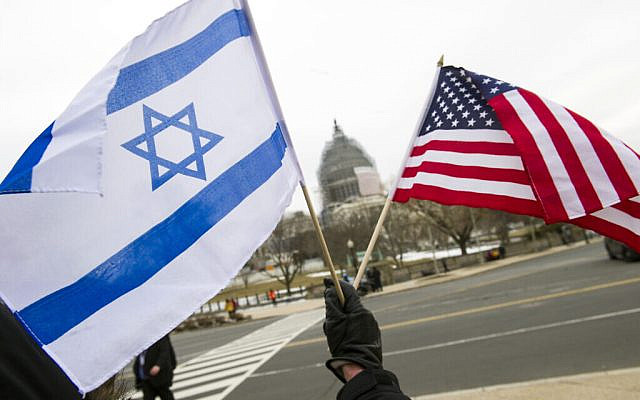 A pro-Israel demonstrators waves flags, toward the Capitol in Washington, Tuesday, March 3, 2015, as Israeli Prime Minister Benjamin Netanyahu addressed a joint meeting of Congress. In a speech that stirred political intrigue in two countries, Netanyahu told Congress that negotiations underway between Iran and the U.S. would "all but guarantee" that Tehran will get nuclear weapons, a step that the world must avoid at all costs. (AP Photo/Cliff Owen)