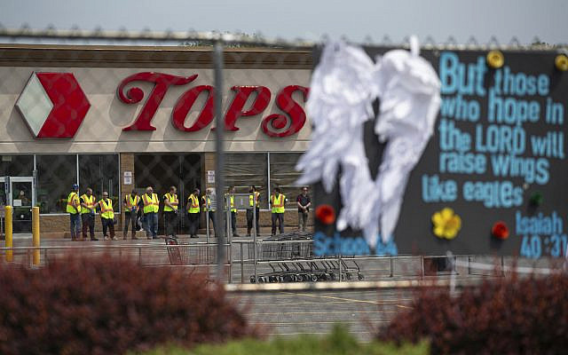 Investigators stand outside during a moment of silence for the victims of the Buffalo supermarket shooting outside the Tops Friendly Market, May 21, 2022, in Buffalo, N.Y. (AP Photo/Joshua Bessex)