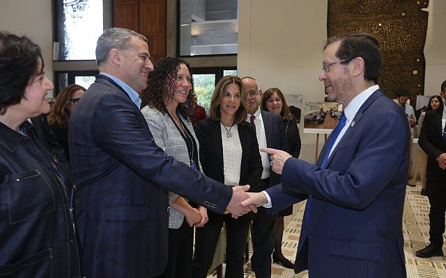 Federation CEO, Gil Preuss (L), shakes hands with Israel's President, Isaac Herzog.