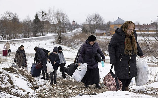 Refugees fleeing conflict make their way to the Krakovets border crossing with Poland on March 9, 2022 in Krakovets, Ukraine. More than a million people have fled Ukraine following Russia's large-scale assault on the country, with hundreds of thousands of Ukrainians passing through Lviv on their way to Poland. (Dan Kitwood/Getty Images)
