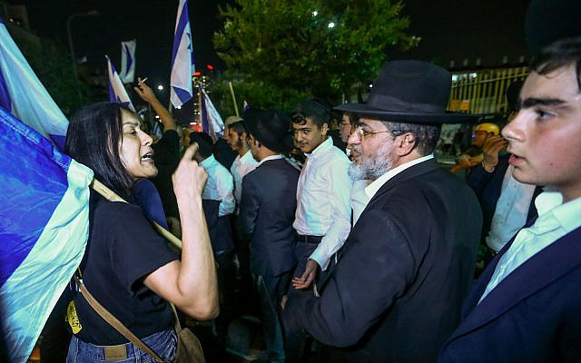 Demonstrators argue with ultra-Orthodox Jews during a protest march in B'nei Brak against funding to ultra-Orthodox parties in the state budget. May 17, 2023 (Flash90)