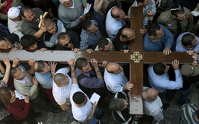 Christian Arab worshipers carry a large wooden cross as they enter the Church of the Holy Sepulchre during the Good Friday procession in Jerusalem’s Old City on April 6, 2012. (Photo credit: Ahmad Gharabli/AFP/Getty Images)