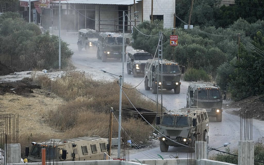 A convoy of army vehicles is seen during a military raid in the Jenin refugee camp, a militant stronghold, in the West Bank, July 4, 2023. (AP Photo/Majdi Mohammed)