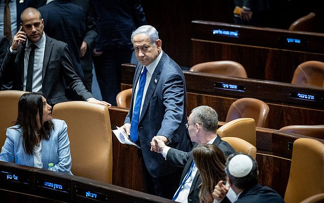 Prime Minister Benjamin Netanyahu shakes hands with Justice Minister Yariv Levin as the Knesset votes to enact the 'reasonableness' law, July 24, 2023. (Yonatan Sindel/ Flash90)
