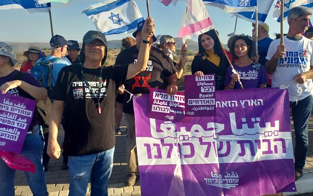 Me and Tahani behind our "This land is all of our home" banner. Photo Credit: Moshe Shalit